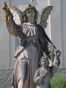 figura Anioła Stróża prowadzącego dziecko za rękę